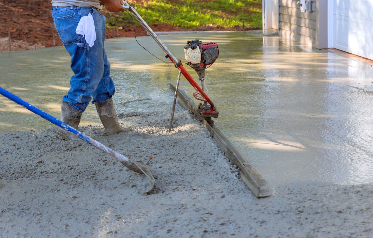Power screed leveling concrete for even surface finish in Carson, CA